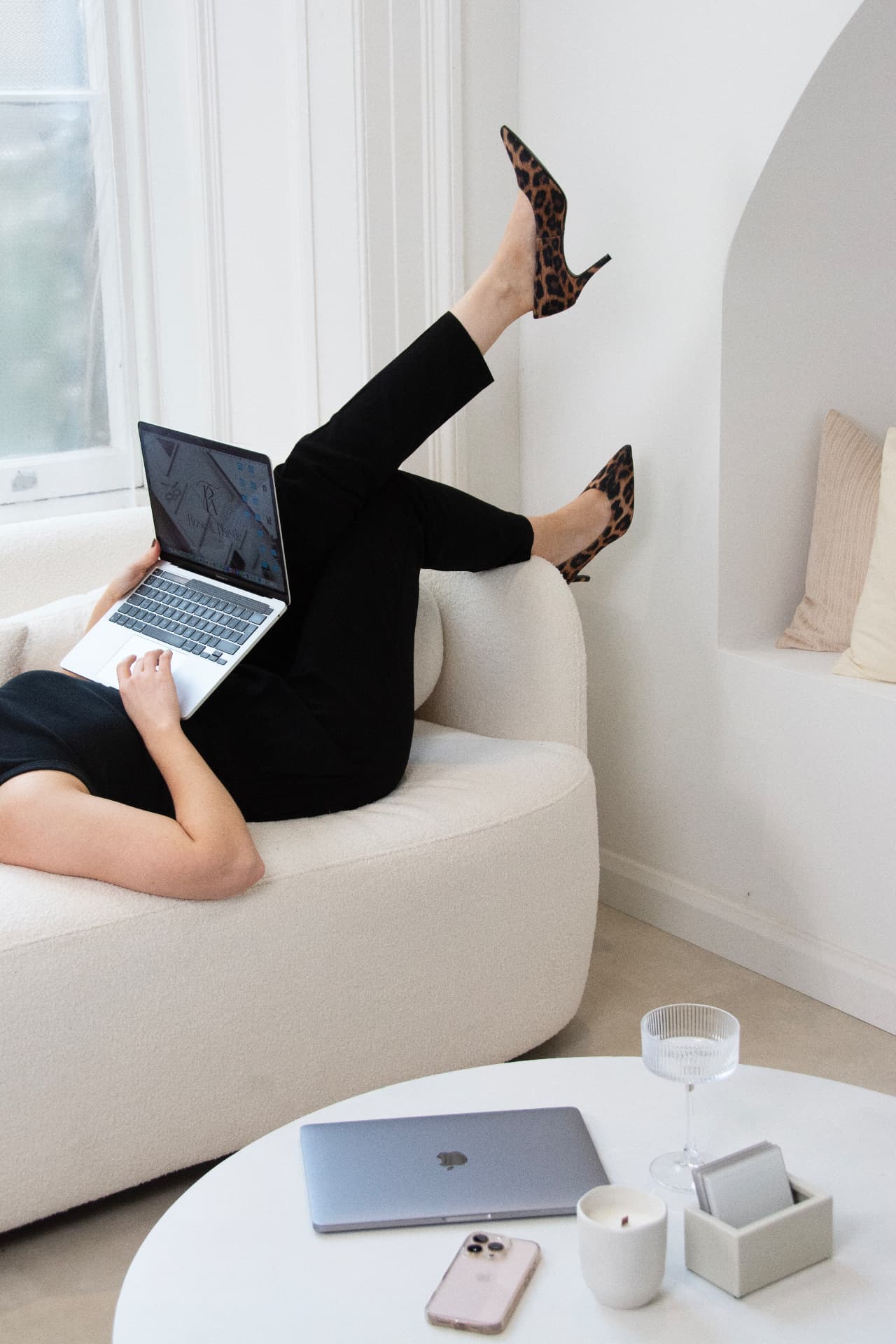Abigail Mills working on a laptop while relaxing on a sofa