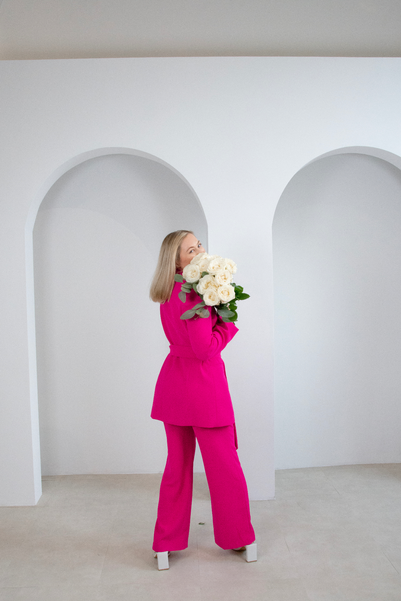 Founder in pink suit with bouquet