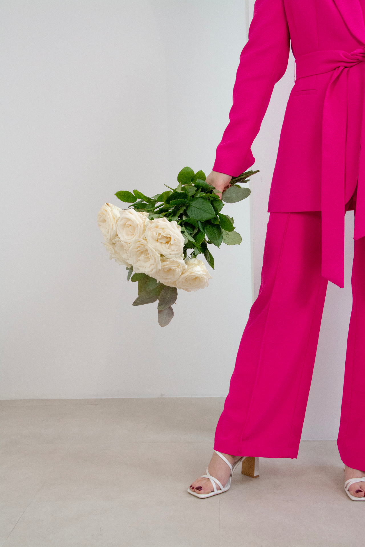 Founder in pink suit holding bouquet